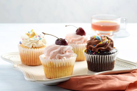 Foto de Cupcakes surtidos de primer plano con aspersiones en un plato - Imagen libre de derechos