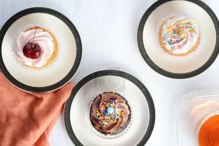 Foto de Vista superior tres cupcakes con taza de té - Imagen libre de derechos