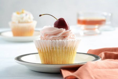 Foto de Primer plano crema de mantequilla de cereza cupcake en el plato - Imagen libre de derechos