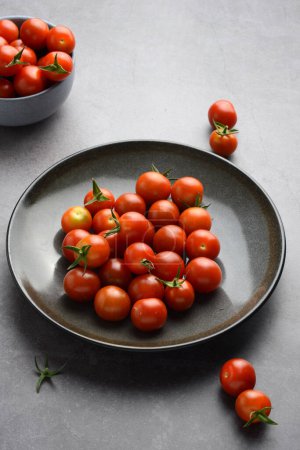 Foto de Primer plano tomates cherry en plato gris - Imagen libre de derechos