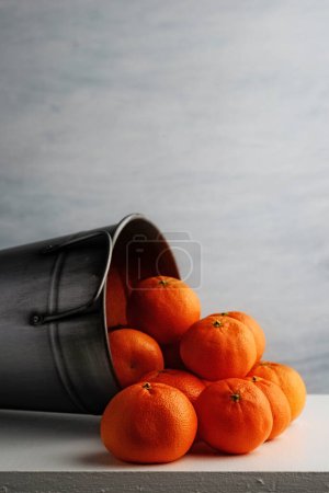 Foto de Primer plano de las naranjas de mandarina en cubo de metal plateado - Imagen libre de derechos