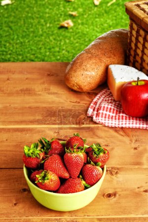 Foto de Mesa de picnic con un tazón verde de fresas - Imagen libre de derechos