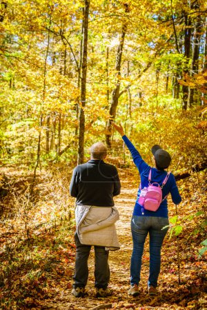 Foto de Senior couple is hiking in the woods in North Carolina in fall - Imagen libre de derechos