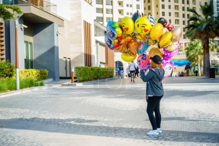 Foto de Dubai, Emiratos Árabes Unidos, 23 de febrero de 2018: Un vendedor de globos para fiestas en la Jumeirah Beach Residence (JBR) Walk - un destino polular para comida, compras y entretenimiento - Imagen libre de derechos
