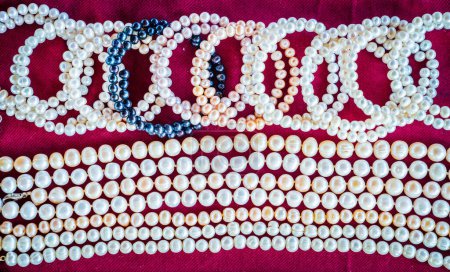 Téléchargez les photos : Colliers de perles de culture sur fond de tissu rouge dans un magasin à Ha Long City, Vietnam - en image libre de droit
