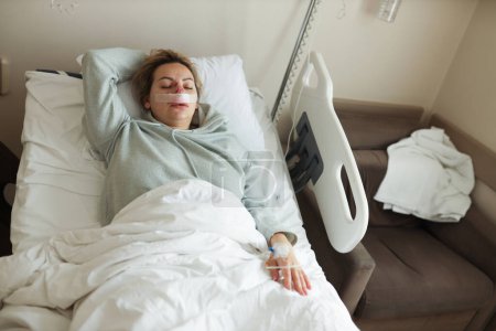 Foto de Una mujer yace en el hospital con una lesión en la nariz - Imagen libre de derechos