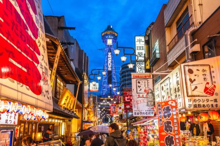 Photo for October 8, 2023: Street view of Shinsekai and Tsutenkaku tower in Osaka, Japan. Shinsekai, lit. New World, is a retro area developed before the war and then neglected in the decades afterwards. - Royalty Free Image