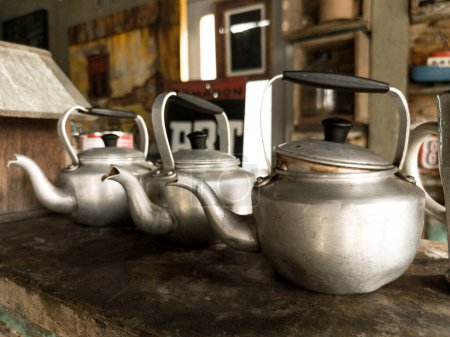 Photo for Aluminum teapots and stove on a dark background. - Royalty Free Image