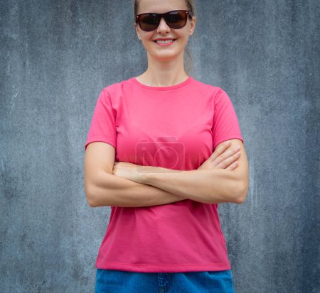 Photo for Female model wearing pink blank t-shirt on the background of an gray scratched wall - Royalty Free Image