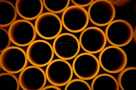 Téléchargez les photos : Contexte des tuyaux en plastique orange empilés. - en image libre de droit