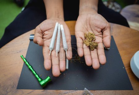 Téléchargez les photos : Jeune homme faisant des cigarettes avec de la marijuana médicale. - en image libre de droit