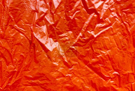 Photo for Wrinkled orange glossy paper as a background texture. - Royalty Free Image