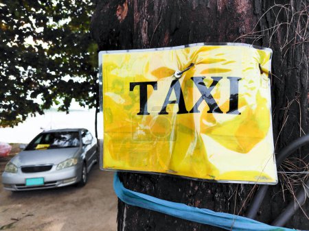 Téléchargez les photos : Taxi attend le client derrière un panneau de taxi en face d'une plage. - en image libre de droit
