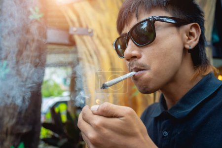 Photo for Young man smoking cigarettes with medical marijuana. - Royalty Free Image