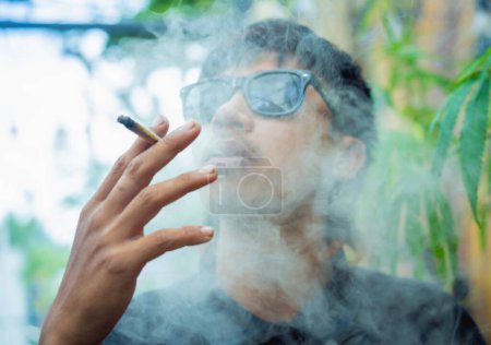 Photo for Young man smoking cigarettes with medical marijuana. - Royalty Free Image