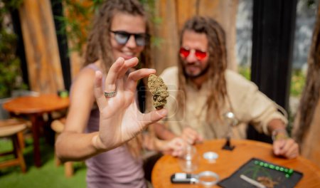 Foto de Estilo hippie pareja examina articulaciones y brotes de marihuana medicinal - Imagen libre de derechos