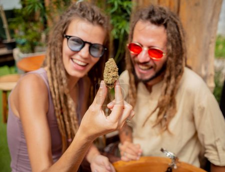 Photo for Hippie style couple examines joints and buds of medical marijuana - Royalty Free Image