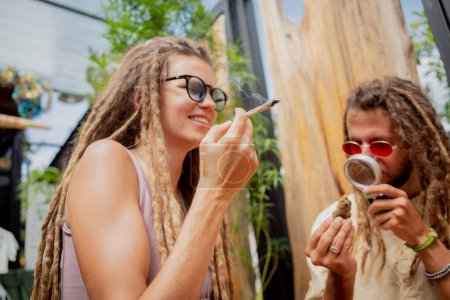 Foto de Estilo hippie pareja fumando cigarrillos con marihuana medicinal. - Imagen libre de derechos