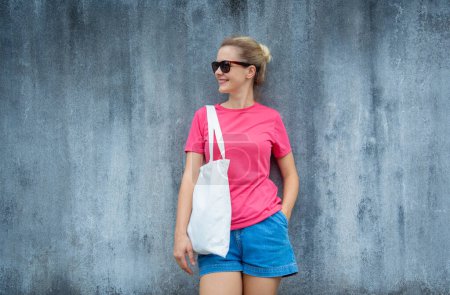 Photo for Female model wearing pink blank t-shirt on the background of an gray scratched wall - Royalty Free Image