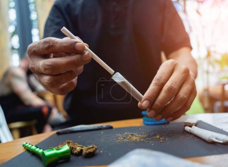 Foto de Joven haciendo cigarrillos con marihuana medicinal. - Imagen libre de derechos