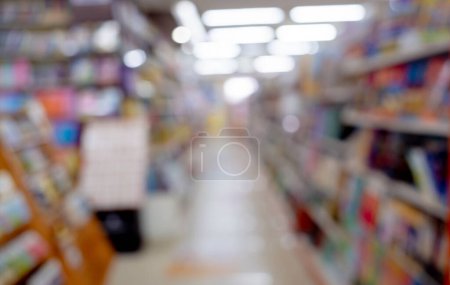 Photo for Bloored background of the book store with different books lying on the shelves. - Royalty Free Image
