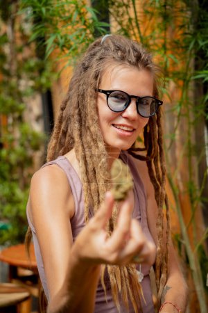 Photo for Hippie style woman examines joints and buds of medical marijuana - Royalty Free Image