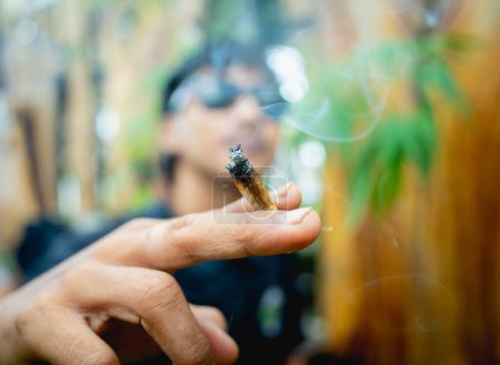 Foto de Hombre joven fumando cigarrillos con marihuana medicinal. - Imagen libre de derechos