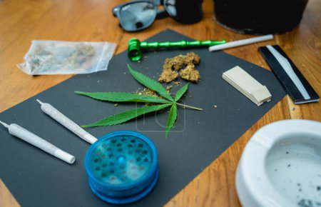 Téléchargez les photos : Joints et bourgeons de cannabis médical et de cigarettes sur une table en bois. - en image libre de droit