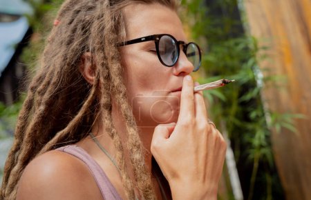 Foto de Estilo hippie mujer fumando cigarrillos con marihuana medicinal. - Imagen libre de derechos