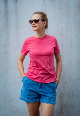 Photo for Female model wearing pink blank t-shirt on the background of an gray wall - Royalty Free Image