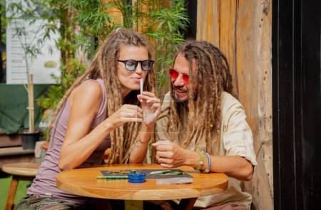 Foto de Estilo hippie pareja haciendo cigarrillos de marihuana medicinal. - Imagen libre de derechos