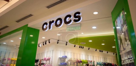 Foto de KUALA LUMPUR, MALAYSIA - DECEMBER 04, 2022: Crocs brand retail shop logo signboard on the storefront in the shopping mall. - Imagen libre de derechos
