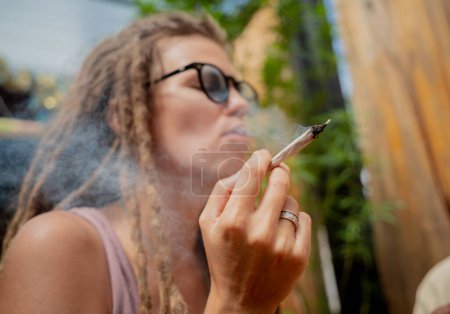 Foto de Estilo hippie mujer fumando cigarrillos con marihuana medicinal. - Imagen libre de derechos