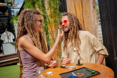 Téléchargez les photos : Hippie couple de style examine les articulations et les bourgeons de marijuana médicale - en image libre de droit