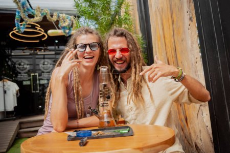 Foto de Estilo hippie pareja fumando cigarrillos con marihuana medicinal. - Imagen libre de derechos