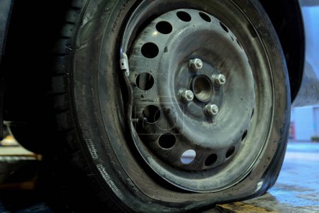 Téléchargez les photos : Car with a punctured and broken wheel in a car repair shop. - en image libre de droit