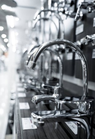 Téléchargez les photos : Rows of metal water taps at the showroom of a large store. - en image libre de droit