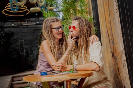 Photo for Hippie style couple smoking cigarettes with medical marijuana. - Royalty Free Image