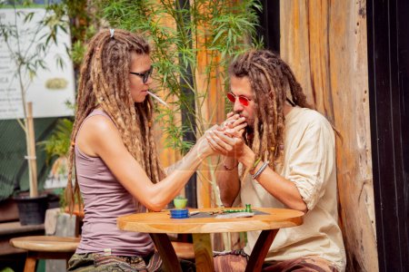 Photo for Hippie style couple smoking cigarettes with medical marijuana. - Royalty Free Image