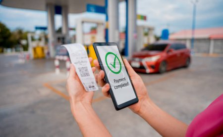 Photo for Woman using contactless payment by mobile phone with QR code at car filling station. - Royalty Free Image