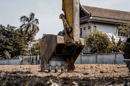 Foto de Excavadora con pala cava el suelo para la fundación en la zona de constucción - Imagen libre de derechos