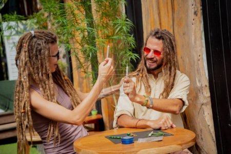Hippie style couple making medical marijuana cigarettes.
