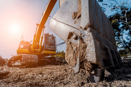 Bagger mit Schaufel gräbt im Baugebiet den Boden für das Fundament