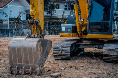 Foto de Excavadora con pala cava el suelo para la fundación en la zona de constucción - Imagen libre de derechos