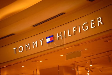 Foto de KUALA LUMPUR, MALASIA - 04 DE DICIEMBRE DE 2022: Tommy Hilfiger brand retail shop logo signboard on the storefront in the shopping mall. - Imagen libre de derechos