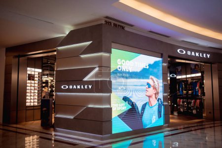 Foto de KUALA LUMPUR, MALASIA - 04 DE DICIEMBRE DE 2022: Letrero de logotipo de la tienda minorista de la marca Oakley en el escaparate del centro comercial. - Imagen libre de derechos