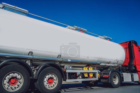 Photo for White tanker truck transporting fuel along the road at the blue sky background. - Royalty Free Image
