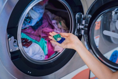 Téléchargez les photos : Jeune belle femme lave et sèche les vêtements dans la buanderie. - en image libre de droit