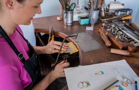 Foto de Joven joyera femenina haciendo joyas en taller. - Imagen libre de derechos