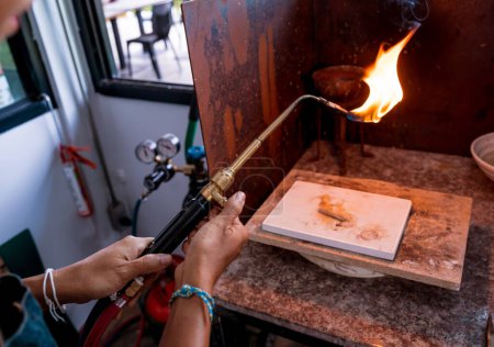 Foto de Joyero usando un quemador para dar forma a una pieza en un taller. - Imagen libre de derechos